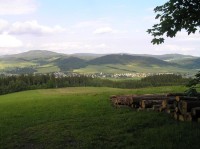 Pohled na Červenou Vodu z úbočí Suchého Vrchu: Vpravo nad vesnicí Křížová hora, nalevo od ní vrch Luzný se sjezdovkou a Kamenáč, za nimi vzadu Jeřáb.