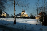 Historické centrum: Kostel, škola a fara v Písečné tvoří historické centrum obce. V pozadí se vypíná kopec Žampach