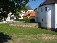 zachovalé hradby navazující na bílou budovu (Muzeum u Vodní branky v Uničově) čelně