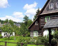 Kostelík (průhled mezi domy u silnice): Dosti vysoko nad ostatními domy středu obce se nachází nejvýznamnější památka obce - dřevěný kostelík sv. Kryštofa a barokní fara.