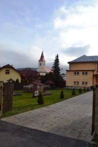 pohľad na kostol cez detské ihrisko pri materskej škôlke