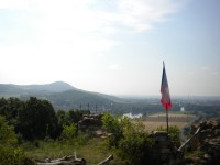 Státní vlajka jako znak češství na Kalvárii z vrcholem Radobýl v pozadí.