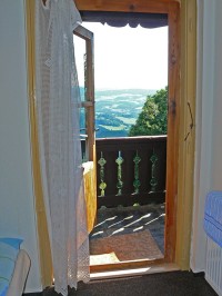 Výhled z pokoje přes dřevěný balkón