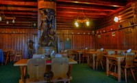Šerlich - interiér jídelny Masarykovy horské chaty (z r. 1925) s nosným válcovým sloupem s dřevořezbou (strom života se znakem KČST) od Leoše Kubíčka 