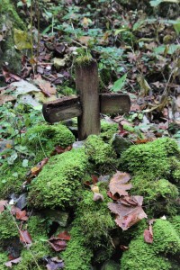 Dřevěný kříž umístěný pod skalní stěnou