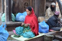 Nepálská žena plete talíře z listů.