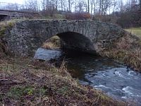 Jednoduchý klenutý kamenný most přes Borovský potok ve Stříbrných horách