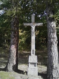 25. Vysoký kamenný kříž s datací.