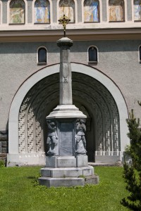 Kříž před vchodem je zároveň pomníkem padlých