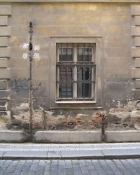 Okno s chátrající fasádou domu U Voříkovských