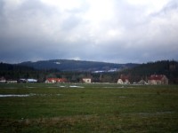 Obec Láz, v pozadí Brdce (839m) a louky na Skelné Huti (715m)
