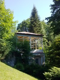 Prosklená terasa v budově lesního mlýna vzadu v parku