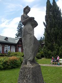 socha mladej ženy a časť budovy Letní lázně