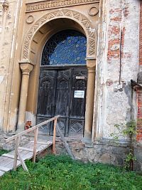 vstupná brána - plastické lemovanie do oblúka s rastlinnými a geometrickými ornamentami a po stranách stĺpy s románskou hlavicou