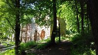 ruiny a chodník okolo kláštora s infopanelom