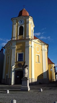 vchod do kostola pod vežou, v popredí socha sv. Jána Nepomuckého