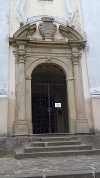 vchod do kostola pod vežou s portálom zdobeným erbom Kryštofa Pruskovského z Pruskova a jeho manželky