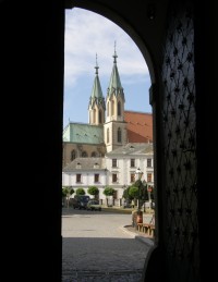 Průhled hlavními vraty ze zámku