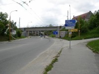 Modře značená cesta k městskému nádraží: MTZ pokračuje za železničním viaduktem ostře vpravo do průchodu