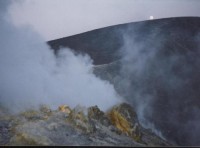 Vulcano 10: Velký kráter - Gran Cratere
Samotný kráter, ležící na vrcholu sopky, má tvar mísovité prohlubně hluboké asi 80 m a až 500 m široké. Na jeho jižním okraji je velké fumarolové pole, neboli pás výronů sopečných plynů. Jejich teplota se pohy