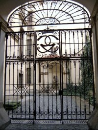 Pohled do dvora: Na malém vstupním dvorku se proti vjezdu nachází barokní mříží chráněná kašna, v jejíž nice je umístěna socha Tritona, rovněž od M. B. Brauna. 