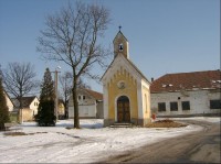 Kaple v obci Dřevec: Zděná kaple s trojbokým závěrem a zvoničkou nad průčelím, okolo roku 1870.