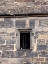 Nápis a okno: Na věžním průčelí je umístěna kamenná deska s latinským nápisem "Měšťané farnosti sv. Petra na Poříčí nákladem veřejným i soukromým tuto věž vděčnému potomstvu vystavěli r. 1598". 