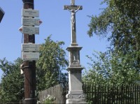 Rozcestník: Pohled na rozcestník v obci, vpravo křížek