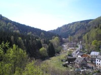 výhled ze skály: Načetínské údolí, vlevo svah české hory Vyhlídka, stavení a silnice za potokem již leží na německém území (město se jmenuje Rothenthal).