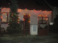 Vánoční stromeček u vánočně rozsvíceného domečku