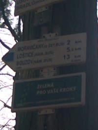 Detail turistických směrovek směrem k Moravičanům (vlakové nádraží) a Bouzovu (hradu)