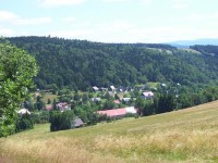 Dolní část obce v létě: Napravo se modrají západní Krkonoše