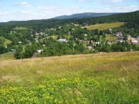 Horní část obce v létě: Na obzoru se rýsují Ptačí kupy a Holubník.