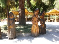 drevené sochy okolo statného smmreka