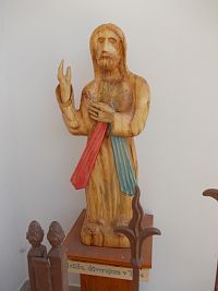 drevená soška ukrytá pri vchode do kostola