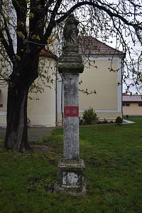 stĺp so sochou Panny Márie, na červenej tabuľke je popiska