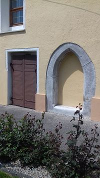 zamurovaný vchod s gotickým portálom
