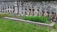 historické pomníčky pri múre stojacom medzi dvomi vstupmi do areálu kostola