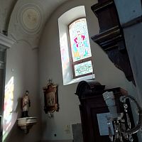 pohľad na okno s vitrážou z vnútra kostola