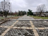 pohľad od plastiky na vchod do areálu