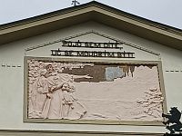 nápis a reliéf v strednej časti priečelia