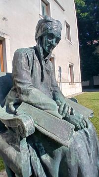 sediaca matka s bibliou na kolenách