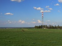 Menší telekomunikační stožár a krajinná placka za ním