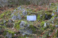 Pamětní deska umístěna v kamenitém svahu pod starým selským lůmkem