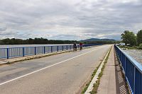Cyklisté na mostě v pozadí panoráma Pálavy
