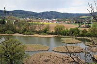 V popředí vodní tůň s ostrůvky za ní objekty Veverské Bítýšky