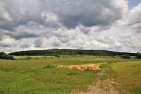 Nad obcí se vypíná rozložitý zalesněný kopec Brusná