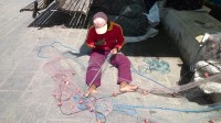Rybář v Marsaxlokku opravuje sítě.