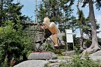 Dřevěný cyklista na vrcholu Třístoličníku.