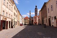 Pohled na mariánský sloup z ulice, v pozadí věž kostela sv. Jakuba